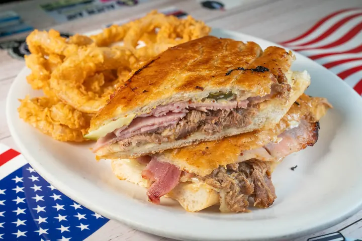Stacked grilled sandwich served with onion rings